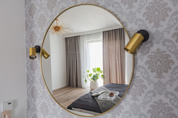 Okrągłe lustro w sypialni w apartamencie