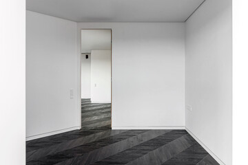 Empty room with dark wooden floating laminate flooring. House interior, wide bedroom or living room space. Newly recently painted new apartment or house. Wood floor. Real estate or property management