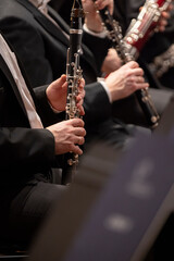 Musicians holding their clarinets and are ready for their cue to play in a classical symphony...