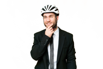 Business person with a bike helmet over isolated chroma key background thinking an idea while looking up