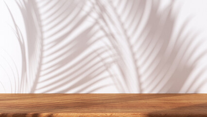 Wooden table with white stucco wall background with window light and palm leaves shadow. Product presentation mock up. Empty interior design concept