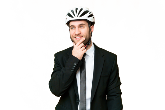Business person with a bike helmet over isolated chroma key background thinking an idea while looking up