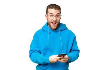 Young handsome blonde man over isolated chroma key background surprised and sending a message