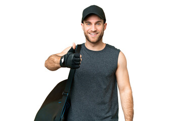 Young sport man with sport bag over isolated chroma key background with thumbs up because something...