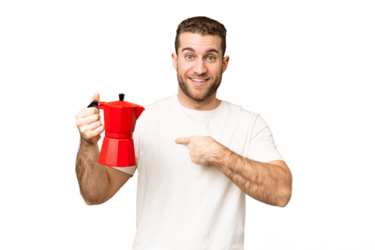 Young handsome blonde man holding coffee pot over isolated chroma key background with surprise facial expression