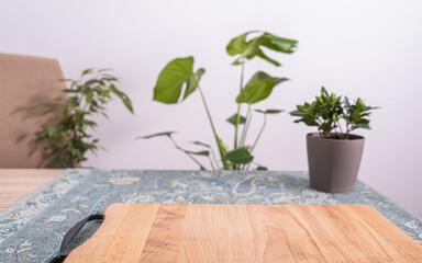 A cutting board with a plant in the background