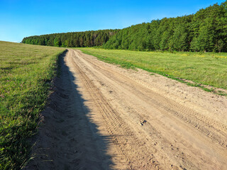 dirt road along a green field