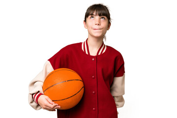Little caucasian girl playing basketball over isolated background and looking up