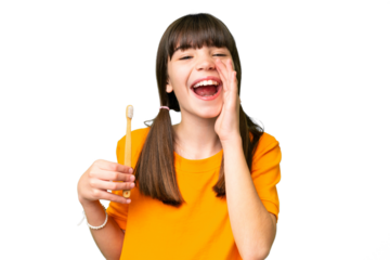 Little caucasian girl brushing teeth over isolated background shouting with mouth wide open