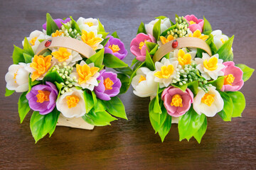 Bouquets of fragrant crocuses daffodils from handmade soap in baskets on a white background.