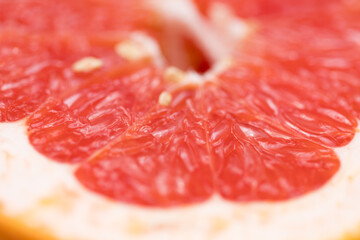 Defocused blurred cut grapefruit macro texture close up with orange grapefruit skin