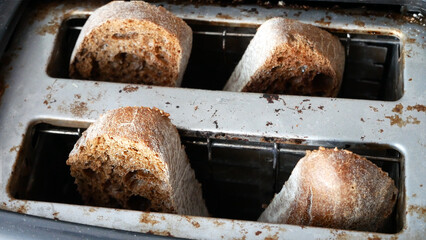 Some beautiful slices of bread are toasted in an old toaster close-up