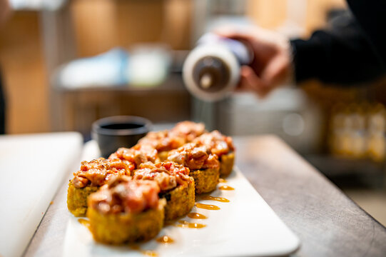 professional chef's hands making sushi and rolls in a restaurant kitchen