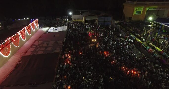 Aerial night view of a crowd of people gathered at a temple for a festival