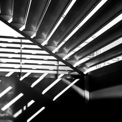 hotel conference. A place for people to rest, for business talks. Black and white photo. A sunny place with armchairs, chairs and a table. The shadow of the sun setting the mood, the stripes on the wa