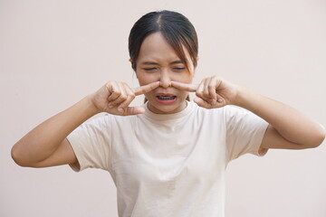 Asian woman having stuffy nose from cold