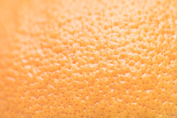 Defocused and blurred grapefruit orange skin macroclose up with pores