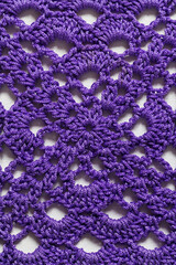 Crochet purple granny square background. Handmade knitted texture. Top view.