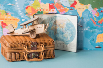 Tourism. A model of a vintage air plane and a suitcase on the background of a world map. The concept of travel, adventure and discovery.