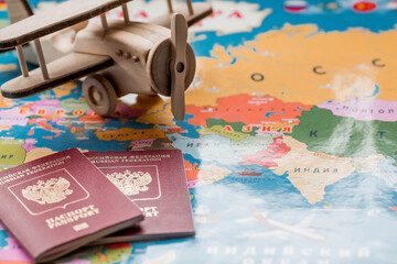 Tourism. A model of a vintage air plane and a Russian passport on the background of a world map. The concept of travel, adventure and discovery.
