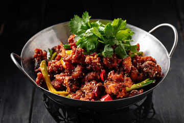 Chinese fried chicken with chili pepper in a wok pan