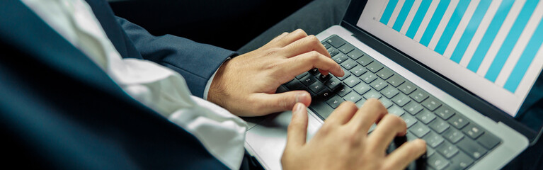 Close up of businessman in suit studies charts and statistics while riding in car
