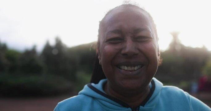 African senior woman looking on camera after sport workout at city park