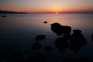 Fototapeta na wymiar Beautiful landscape with colorful sunset on the sea rock beach.