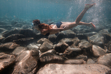 Young woman snorkeling underwater in the sea.