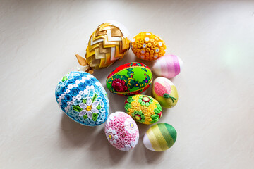 Colorful Easter eggs with floral ornaments, origami decorations and crewel wool against white background, different techniques of Easter eggs decoration, Poland.