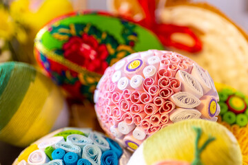 Colorful traditional Easter eggs with floral ornaments, origami decorations and crewel wool,...