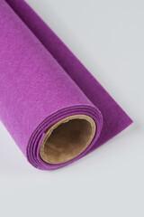 Soft felt textile material purple colors, colorful texture fabric roll closeup