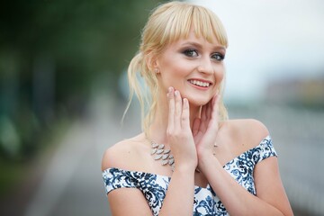 Portrait of a young beautiful girl in the park. Beautiful dress and makeup. Festive image