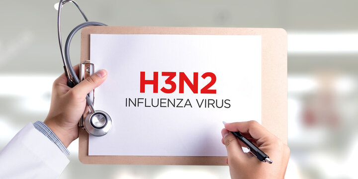 H3N2 influenza virus. Medical doctor hand with a white clipboard with word H3N2. Metallic pen and stethoscope. Medical, H3N2 virus concept.