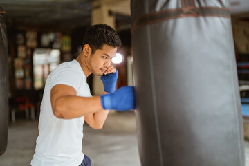 a boxer seriously punching the heavy bags at the boxing studio