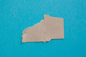 Torn paper piece isolated on a blue background