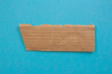 Torn cardboard piece on a blue background