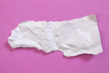 Obraz premium White crumpled torn paper piece isolated on a pink background