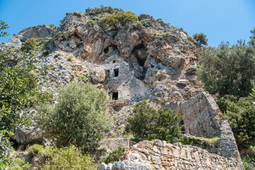 Fototapeta na wymiar Ruins of Afkule monastery carved into rocks by the Mediterranean coast near Kayakoy village in Mugla province of Turkey.