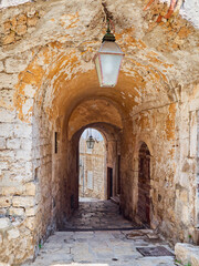Fototapeta na wymiar Charming passage, stone old archway in Dubrovnik Old Town. Croatia, Europe
