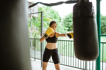 a beautiful boxer seriously punching the heavy bags at the boxing studio