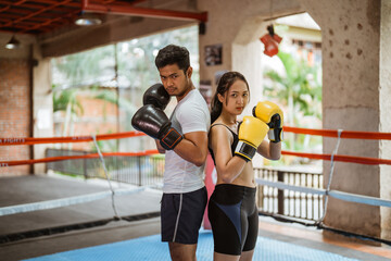 the female boxer and the male boxer standing back to back with the boxing moves at the center of...