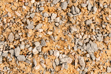 Pieces of gravel lying on the sand.