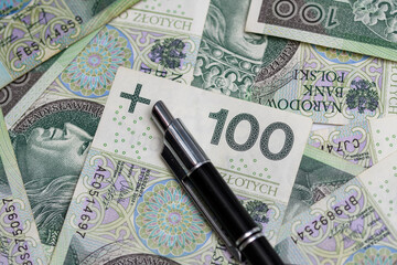 Banknot o nominale 100 złotych polskich przyciśnięty długopisem  - obrazy, fototapety, plakaty