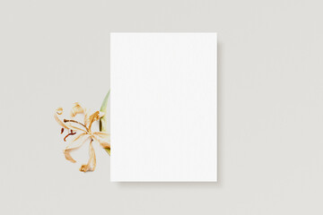 White invitation 5x7 ratio card mockup with orchid flower on beige background. Minimalistic aesthetic template