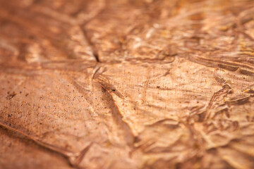 Extreme closeup of crumpled brass foil texture