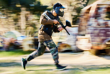 Fast, running and paintball man, gun and outdoor battlefield, playground or games in forest adventure training. Shooting skill, player or sports person with military speed, action and target mission