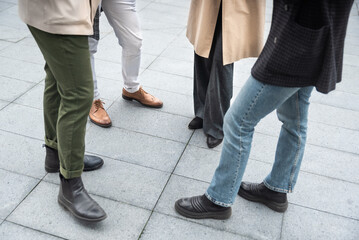 Unrecognizable young businesspeople standing in front of office building talking sharing experience about success business ideas and suggestions improving working conditions of employees and clients
