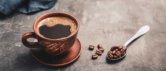 Küchenrückwand glas motiv Kaffee und Kaffeebohnen Black coffee drink in a brown clay cup and coffee beans in a spoon on dark background  © O.Farion