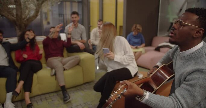Fun life in the office, colleagues play and sing together, modern office space